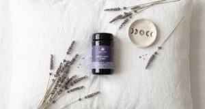Hemponic Good Night Dose mit 60 veganen Kapseln auf einem Nachttisch neben einem Glas Wasser als Teil der Abendroutine.